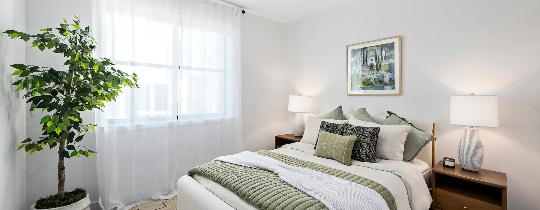 bedroom with bed plant lamps and windows